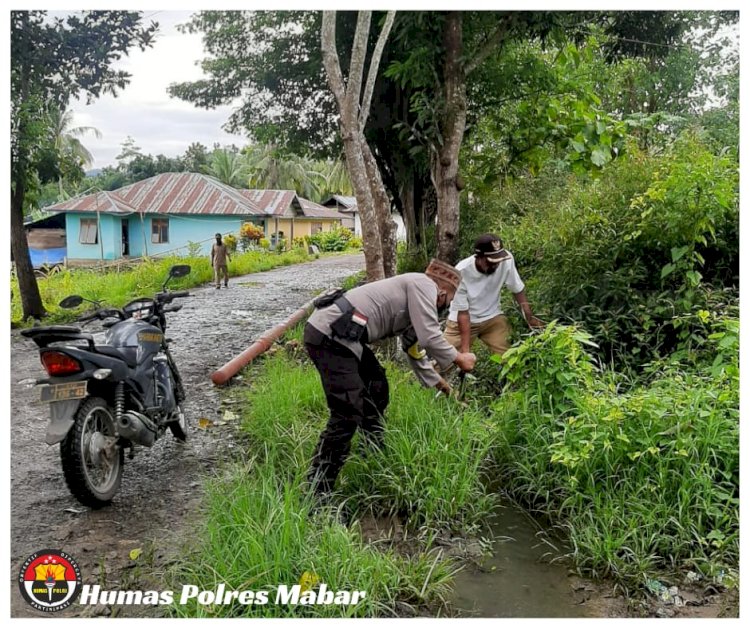 Gotong Royong, Bhabinkamtibmas Bersihkan Saluran Irigasi Bersama Warga