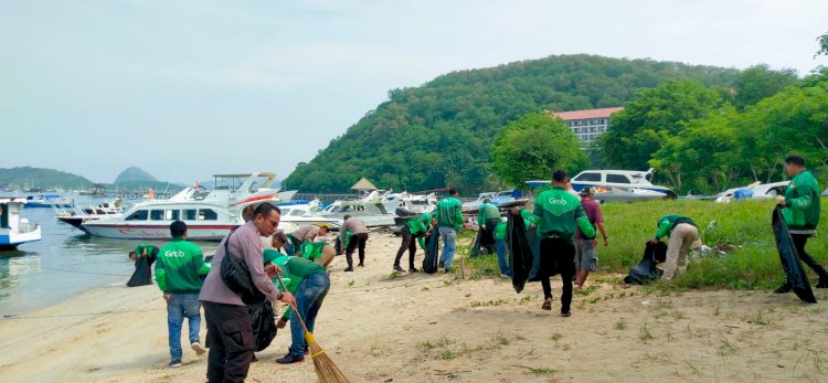 Polisi Bersama Komunitas Ojol Bersihkan Sampah di Pantai Pedde Labuan Bajo