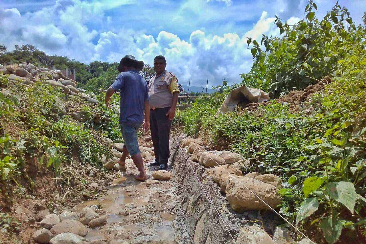 Bhabinkamtibmas Desa Watu Nggelak monitor pembangunan saluran drainase