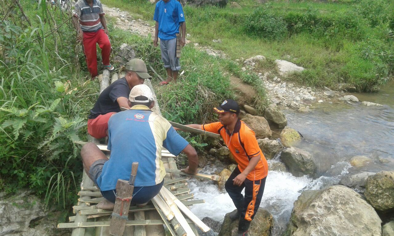 Bhabinkamtibmas Desa Tentang gotong royong bersama warga bangun jembatan darurat